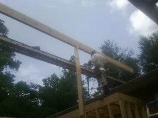 Carpenter setting a ridge beam over a new addition frame — Ice Dam Removal by Roofing Brothers in Upperville