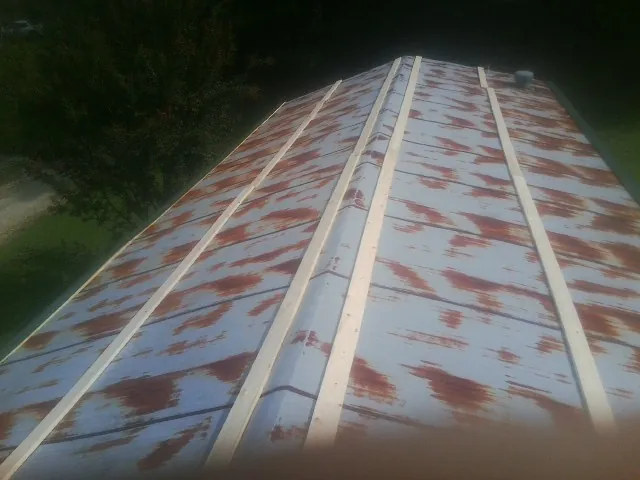 Rusted metal roof panels with new wood purlins before replacement — Storm Damage Roof Repair in Upperville by Roofing Brothers