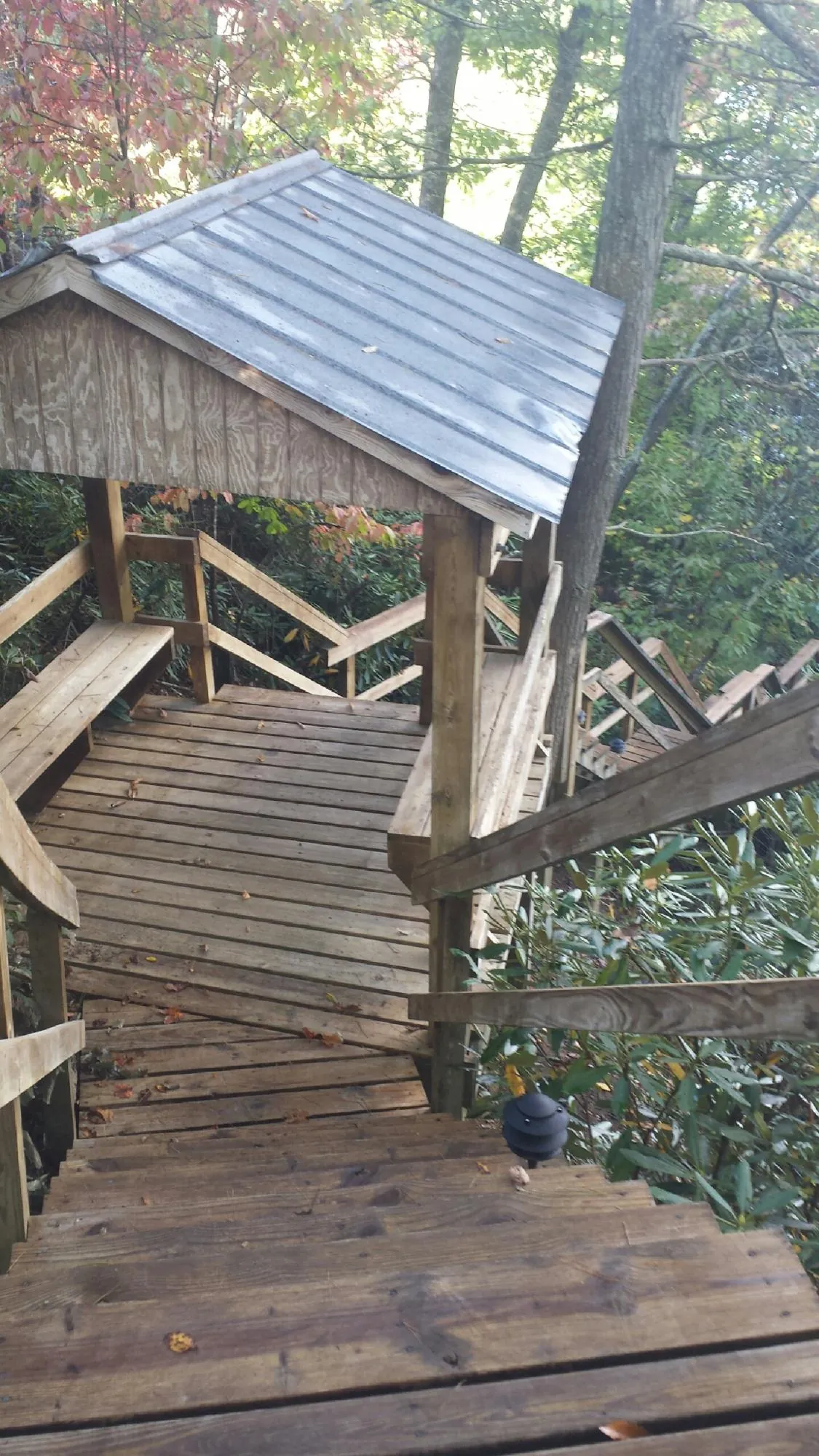 Metal roofed shelter over wooden steps on a wooded walkway — Skylight Repair & Installation work by our crew in Upperville