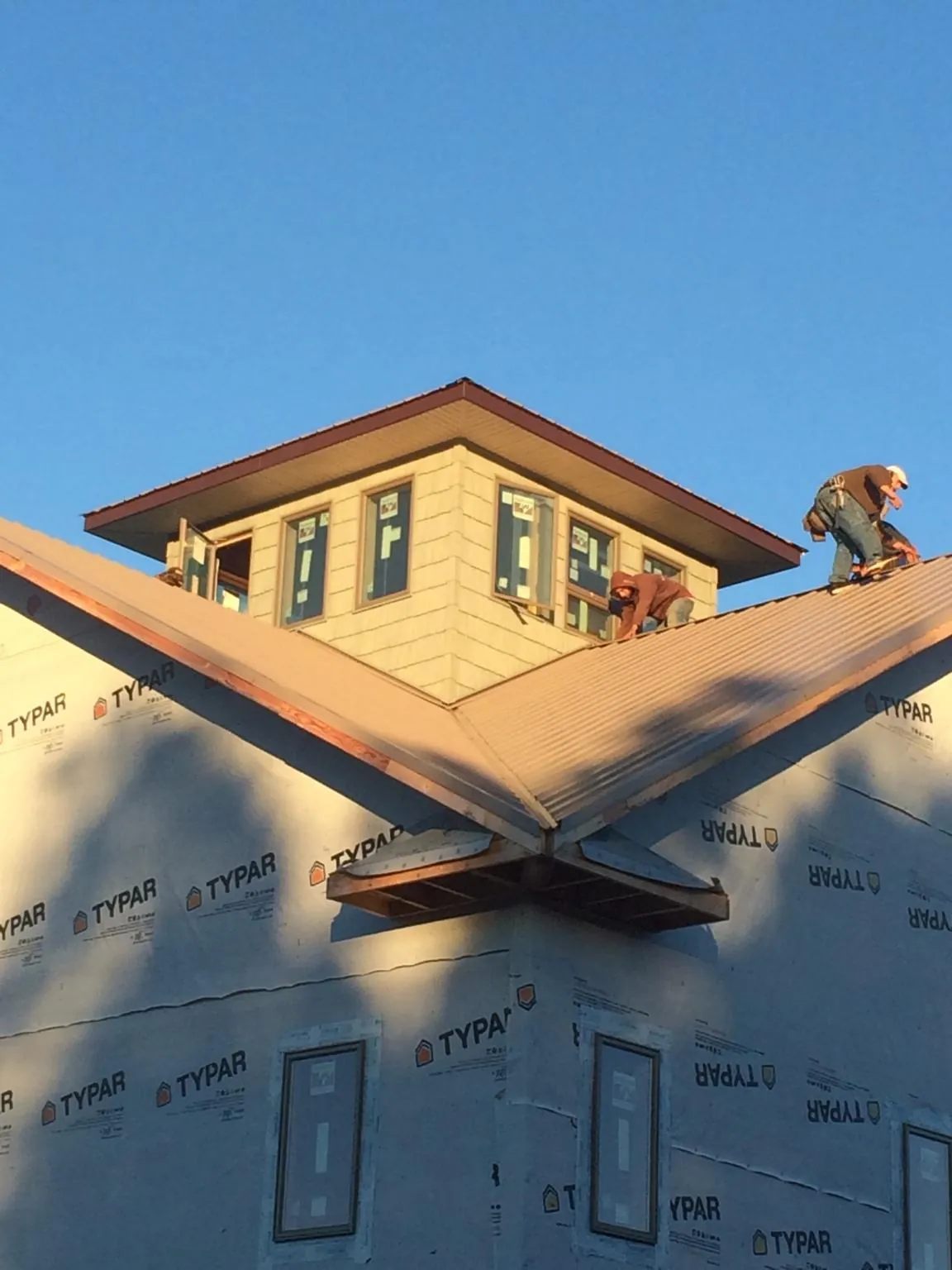 Roofers working around a rooftop cupola on a new metal roof at sunset — Roof Waterproofing in Upperville by Roofing Brothers